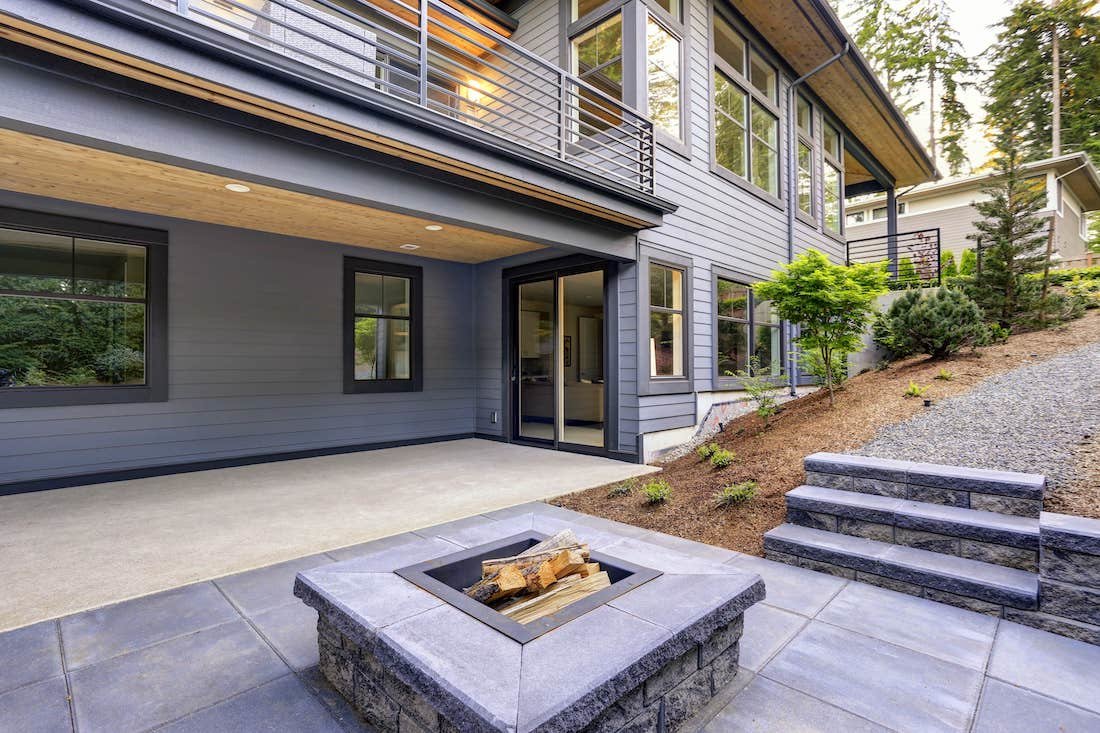 Exterior of backyard, stone patio and fire pit.